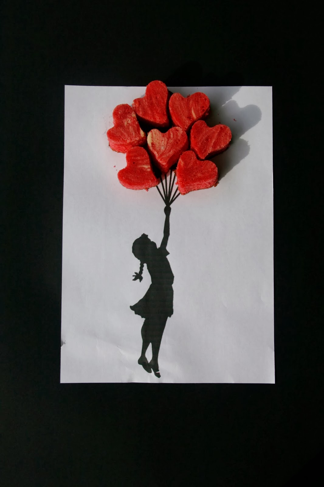 Imatge de la nena amb globus de Banksy amb cors de cheescake red velvet brownie