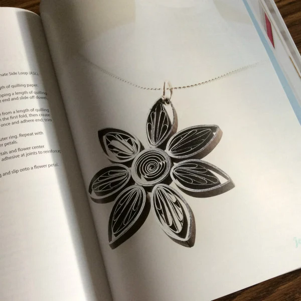 silver and black quilled alternate side loop flower pendant on a fine silver necklace chain