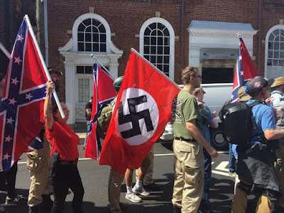 Demonstrators hold Confederate and Nazi flags in Charlottesville, Virginia. Demonstrators hold Confederate and Nazi flags in Charlottesville, Virginia.