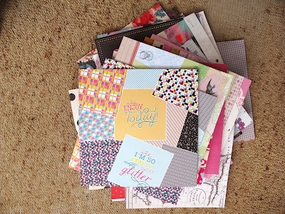 Pile of scrapbooking paper pads on the floor.
