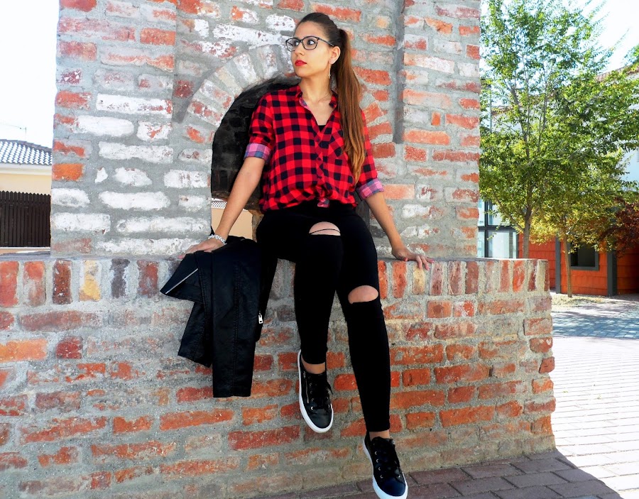 Camisa de cuadros con chaqueta de cuero, jeans rotos y bambas