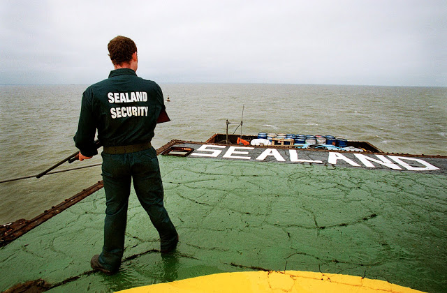 Recent photo of the Principality of Sealand. An armed guard wearing a Sealand Security shirt stands on the platform. Pirate Radio and Sealand and Other stories of Rock, Radio, and Regulations. Marchmatron.com Recent photo of the Principality of Sealand. An armed guard wearing a Sealand Security shirt stands on the platform. Pirate Radio and Sealand and Other stories of Rock, Radio, and Regulations. Marchmatron.com