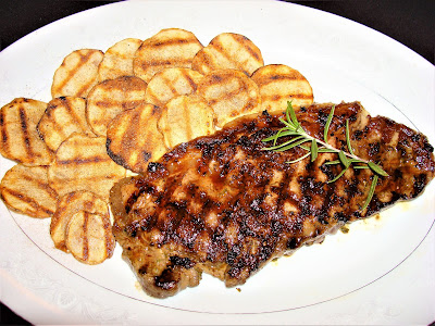 N.Y. STRIP GRILLED LOIN STEAK WITH ROSEMARY AND GARLIC.  CAJUN SPICED POTATOES CHIPS PORTIONS: 2 INGREDIENTS 2 N.Y. strip loin steaks 340 g. /12 oz. each 2 garlic cloves 1 tbsp. rosemary leaves ¼ tsp. salt 1/8 tsp. ground black pepper 1 tsp. olive oil METHOD Chop the garlic and rosemary leaves. Make a paste by putting the mixture in a stone mortar and pestle. Finish the paste by adding olive oil. Season the steaks with the paste and leave at room temperature for 1 hour. Heat up a top stove griddle and grill the steaks as you like it. CAJUN SPICED CHIPS PORTIONS: 2 2 large Idaho potatoes with skin. Thinly sliced with a knife or mandolin 1 tbsp. olive oil Cajun spices METHOD Place the sliced potatoes in a bowl with cold water for about 10 minutes. Dry them with a towel. Heat up a top stove griddle. Coat the potatoes with a bit of olive oil and grill them on both sides. After finish cooking, dust them with Cajun spices. CAJUN SPICES MIXTURE INGREDIENTS 3 tsp. salt 2 tsp. garlic powder 1 tsp. onion powder 2 tsp. paprika powder ½ tsp. smoked paprika powder 1 tsp. chili powder 1 tsp. ground black pepper ¾ tsp. cayenne powder 1¼ tsp. dry oregano 1¼ tsp. thyme leaves 1 tsp. ground cumin PREPARATION Mix the spices well, and place it in an air seal container.