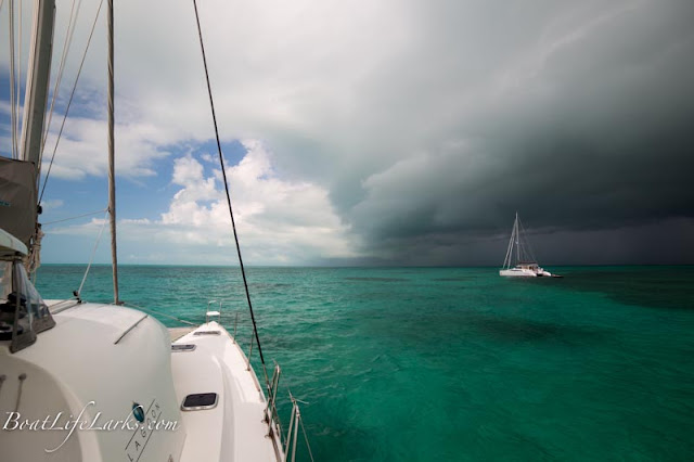 Catamarans at anchor under storm clouds, Bahamas