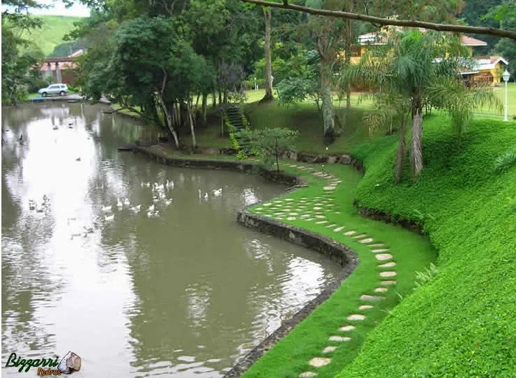 Nesse sítio em Nazaré Paulista-SP a construção do lago e os caminhos de pedra com cacão de São Tomé com a execução do paisagismo e no talude a grama amendoim.