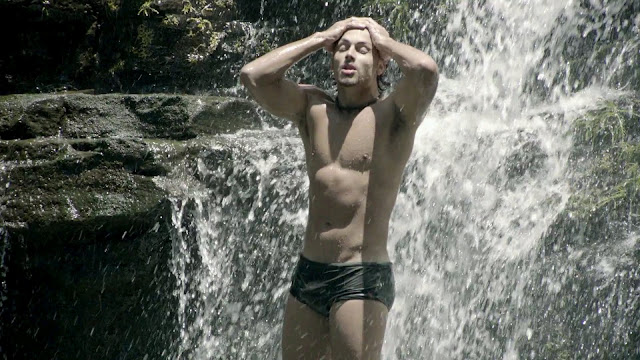 De sunga, Jesus Luz toma banho de cachoeira em cena do clipe "Caliente", da cantora Inna