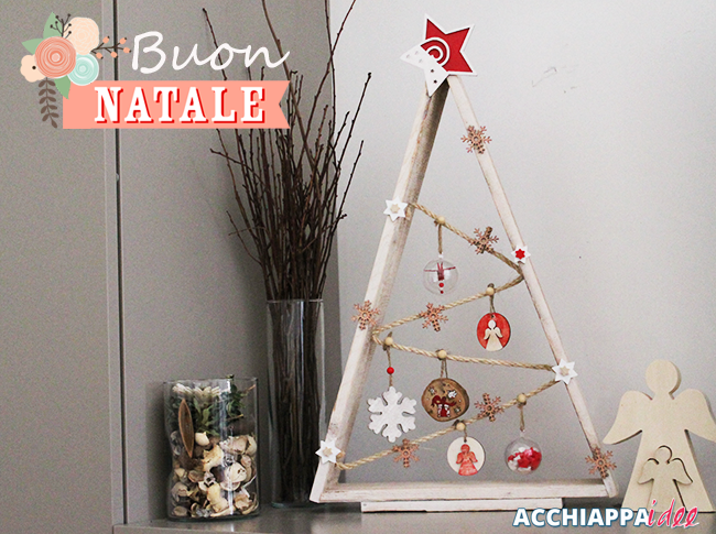 Albero di natale in legno decorato con materiali naturali