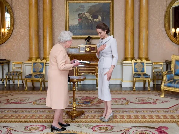 Actress Angelina Jolie is presented with the Insignia of an Honorary Dame Grand Cross of the Most Distinguished Order of St Michael and St George by Queen Elizabeth II in the 1844 Room on 10.10.2014 at Buckingham Palace