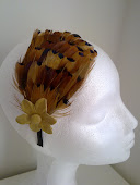 Tocado de plumas con flor de piel natural, sobre siadema forrada de raso.