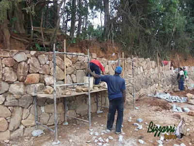 Construção do muro de pedra bruta sendo o tipo de pedra moledo com cores variadas sendo tipo de muro de pedra com junta seca sem massa nas juntas. Muro de pedra na cidade de Joanópolis-SP.