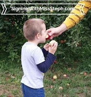 4 year old tastes an apple held out to him