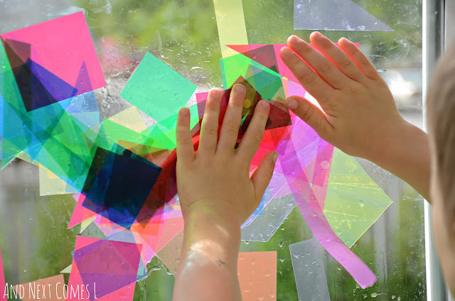 Closeup of a child's hands making abstract window art using natural light