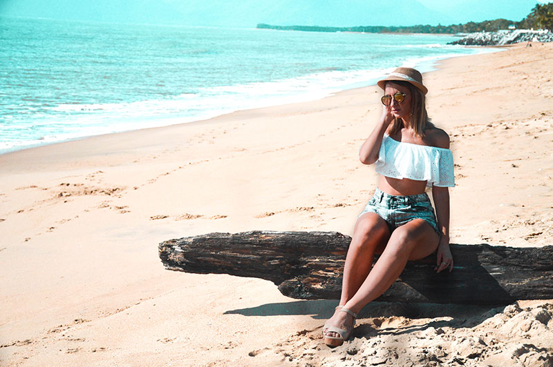 vacation holiday summer beach outfit off shoulder white top denim shorts wedge heels and hat on far north queensland cairns beach vacation holiday summer beach outfit off shoulder white top denim shorts wedge heels and hat on far north queensland cairns beach