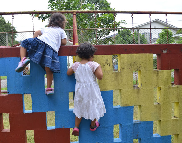 little girls climbing over the wall