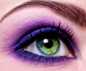 ojo verde maquillado en lila