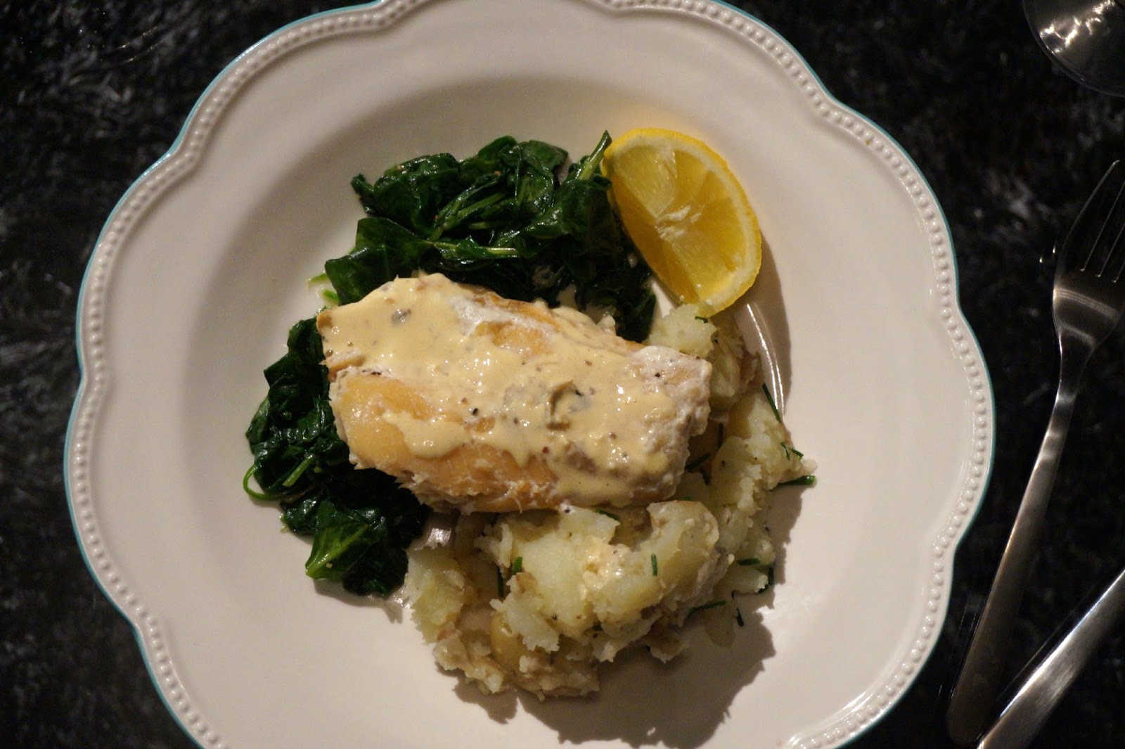 white plate with cod, spinach and cream sauce