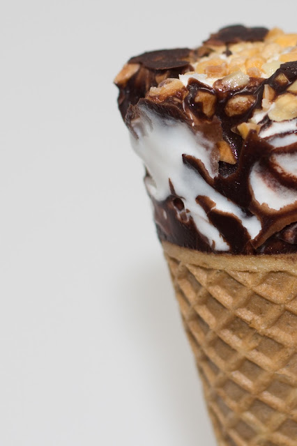 Close up of Valsoia Dairy Free Almond Gelato Cone with waffle cone, vanilla almond based ice cream, chocolate and nuts