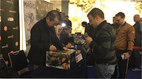 Yu Suzuki signs the box of a Lan Di figure for a fan.
