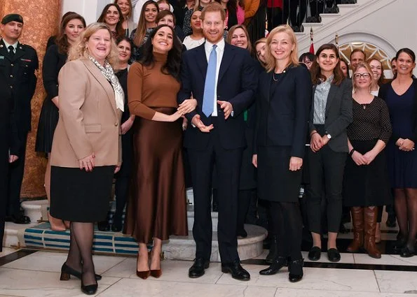 Meghan Markle wore Stella Mccartney double-breasted wool coat and Massimo Dutti brown satin midi skirt. Prince Harry