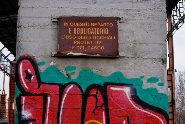 immagine: vecchio cartello di fabbrica e Graffiti in Parco Dora