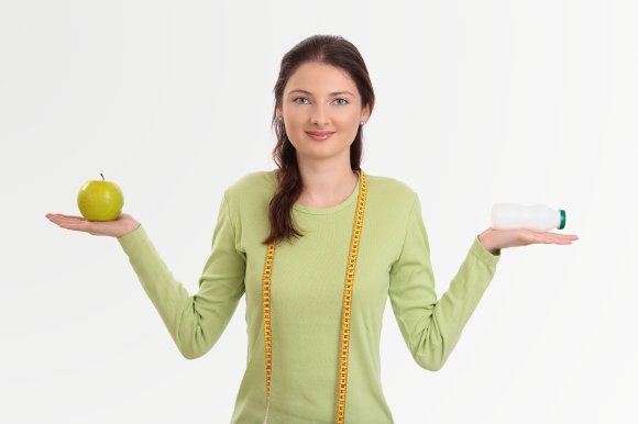 woman holding probiotic and apple
