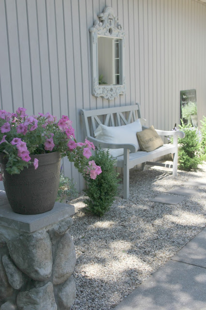 Beautiful French inspired pea gravel courtyard with bench and mirror - Hello Lovely Studio