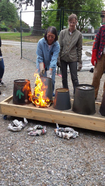 Raku firing - covering the pottery pieces in sawdust and paper and a can.
