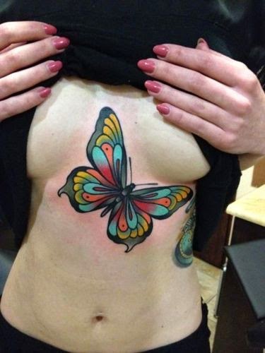 Tatuaje de mariposa entre los pechos y abdomen