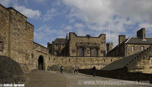Edinburgh Castle is a fortress which dominates the skyline of the city of Edinburgh, Scotland !!! Human habitation of the site is dated back as far as the 9th century BC, although the nature of early settlement is not clear.  As one of the most important fortresses in the Kingdom of Scotland, Edinburgh Castle was involved in many historical conflicts, from the Wars of Scottish Independence ...Although Edinburgh Castle is formally owned by the Ministry of Defence of Scotland but most of the castle is now in the care of Historic Scotland and it is Scotland's most-visited paid tourist attraction.Edinburgh - Castle and train station !!The garrison left in the 1920s, but there is still a military presence at the castle... Military is largely ceremonial and administrative and including a number of regimental museums. It is the backdrop to the annual Edinburgh Military Tattoo and has become a recognizable symbol of Edinburgh and of Scotland.Another view of Edinburgh City from Royal Castle touching skylines..Inside Edinbugh Castle with some barracks on the left !!!!Inside Edinburgh CastleChapel inside Edinbugh Castle...People walking inside Inside Edinburgh CastleEdinburgh Castle - Mons MegMons Meg is a medieval super-gun now located at Edinburgh Castle, Scotland. There are varied views about it's origins, but it appears from the accounts of Philip the Good, Duke of Burgundy that it was made to his order around 1449 and sent as a gift 8 years later to King James II of Scotland, with other artillery supplies... This is picked from Wikipedia !Edinburgh Castle - Walking on the streets..View of Edinburgh city from Castle...St. Margaret's Chapel inside Edinburgh Castle - One on the oldest sections of this Castle !!!St. Margaret's Chapel in inside Edinburgh Castle of Scotland and it's the oldest surviving building in Edinburgh, Scotland. An example of Romanesque architecture, it is a Category A listed buildingLegend had it that St. Margaret worshiped in this small chapel, but recent research indicates that it was built at the beginning of the 12th century by her fourth son who became King David in 1124. The building has been restored and the interior presents much the same appearance as it did when first in use.Some colorful paintings form St. Margaret's Chapel inside Edinburgh Castle - One on the oldest sections of this CastleHalf Moon Battery and David's Tower...The Half Moon Battery, which remains a prominent feature on the east side of the castle, was built as part of the reconstruction works..Edinburgh Castle - Canons on the outer walls of this CastlView of Edinburgh City from Castle ...Oldest building in the castle, and in Edinburgh, is the small St. Margaret's Chapel ...Oldest building in the castle, and in Edinburgh- small St. Margaret's ChapelThe Royal Palace in Crown SquareThere are clear Directions about the places inside Edinburgh Castle - Royal Apartments, Great Hall etcThe Royal Palace comprises the former royal apartments which were the residence of the later Stewart monarchs. It was begun in the mid 15th century and it originally communicated with David's Tower.The Royal Palace in Crown Square - Inside Edinburgh Castle ... A closer look !!!Flag inside Edinburgh Castle ..There are lots of cannons on outer walls of Edinburgh Castle from where whole city is clearly visible ... Since it's situated on height, these areas give wonderful view of Edinburgh City !!The Scottish National War Memorial inside Edinburgh Castle - Scotland by Ashish ...The Scottish National War Memorial is located inside Edinburgh Castle and commemorates Scottish soldiers... It's for those serving with Scottish regiments, who died in the two world wars and in more recent conflicts. The monument was formally opened in 1927. It is housed in a redeveloped barrack block in Crown Square, at the heart of the castle, and incorporates numerous monuments.Inside Edinburgh Castle - People walking in Relaxed mode ...Canon areas inside Edinburgh Castle - Scotland Travel Photo Journey by Ashish ..A View of Edinburgh City from Castle of Edinburgh ..Beautiful Edinburgh City with nice view to the water-body in background...Architecture of Edinburgh City and Castle is really lovable... n would want to click photographs of such places again in future..Tourists looking at the map to ensure that they don't miss anything inside the castle. Also it helps to know which are main attractions which must be visited and which others can be compromised as per available time...Beautiful buildings around Royal Mile in Edinburgh city !!!The Royal Mile is a succession of streets which form the main thoroughfare of the Old Town of the city of Edinburgh in Scotland.Part of the Royal mile inside Edinburgh city of Scotland ...The Royal Mile is approximately one Scots mile long and runs between two foci of history in Scotland, from Edinburgh Castle at the top of the Castle Rock down to Holyrood Abbey. The streets which make up the Royal Mile are (west to east) Castle Esplanade, Castlehill, Lawnmarket, High Street, Canongate and Abbey Strand. The Royal Mile is Edinburgh Old Town's busiest tourist street...Edinburgh Castle is huge as you might have got an idea from all these photographs.. See the size of people roaming around and building around... This photograph must be helpful in setting right perspective about buildings inside Castle !!!Camera Obscura at Edinburgh City of Scotland ...The camera obscura is an optical device that projects an image of its surroundings on a screen. It is used in drawing and for entertainment, and was one of the inventions that led to photography. The device consists of a box or room with a hole in one side. Light from an external scene passes through the hole and strikes a surface inside where it is reproduced, upside-down, but with color and perspective preserved. The image can be projected onto paper, and can then be traced to produce a highly accurate representation.