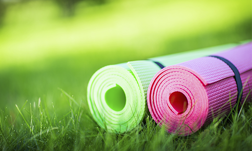 Rolled yoga style mats in the grass.