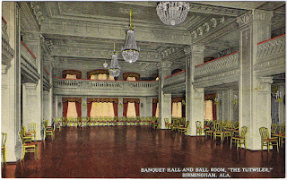 An inside image of Tutwiler hotel's Large dining room with three ceiling lamps,lots of tables and wooden floor