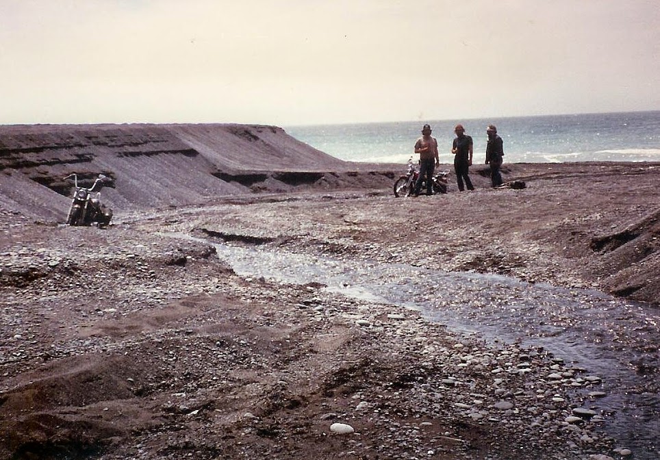 Men and motorcycles on black sands beach