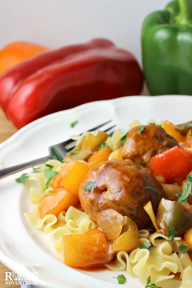 Sweet and Sour Ground Pork Meatballs by Renee's Kitchen Adventures on a white plate with fork and pasta as a complete meal