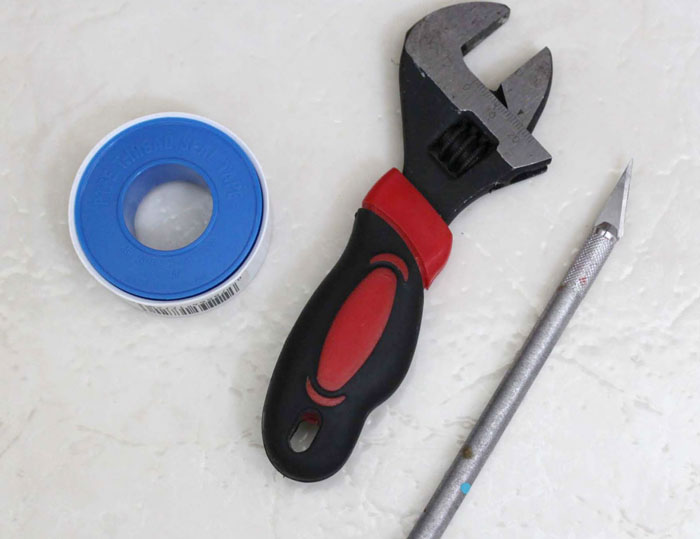 thread seal tape, wrench and an X-acto knife