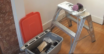 some basic interior painting tools displayed on a two step stepladder