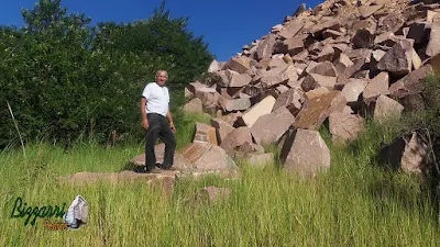 Bizzarri, da Bizzarri Pedras, fazendo o que gosta, garimpando pedra na pedreira. Na foto, escolhendo pedras de granito vermelho, sendo pedras para banco de pedra, mesa de pedra, paisagismo com pedras, escada de pedra, todas essas relíquias de pedra. Verdadeiras peças únicas que vão ser enterradas manualmente com terra boa e transformando essa área em mata nativa. Da dó de ver essa pedra bruta, tantas construções com pedras que da para fazer com essas pedras.