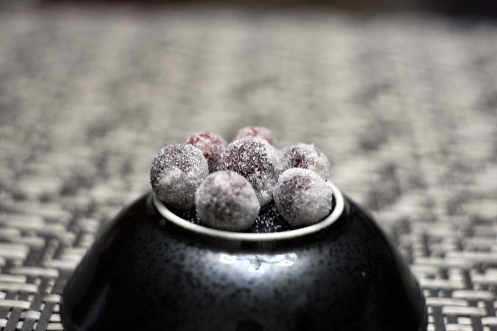 An inverted bowl displaying seven sugar frosted cranberries.