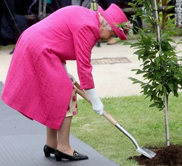 Queen Elizabeth wore a floral satin dress, pink coat and pink hat, pearl necklace, pearl earrings and diamond brooch