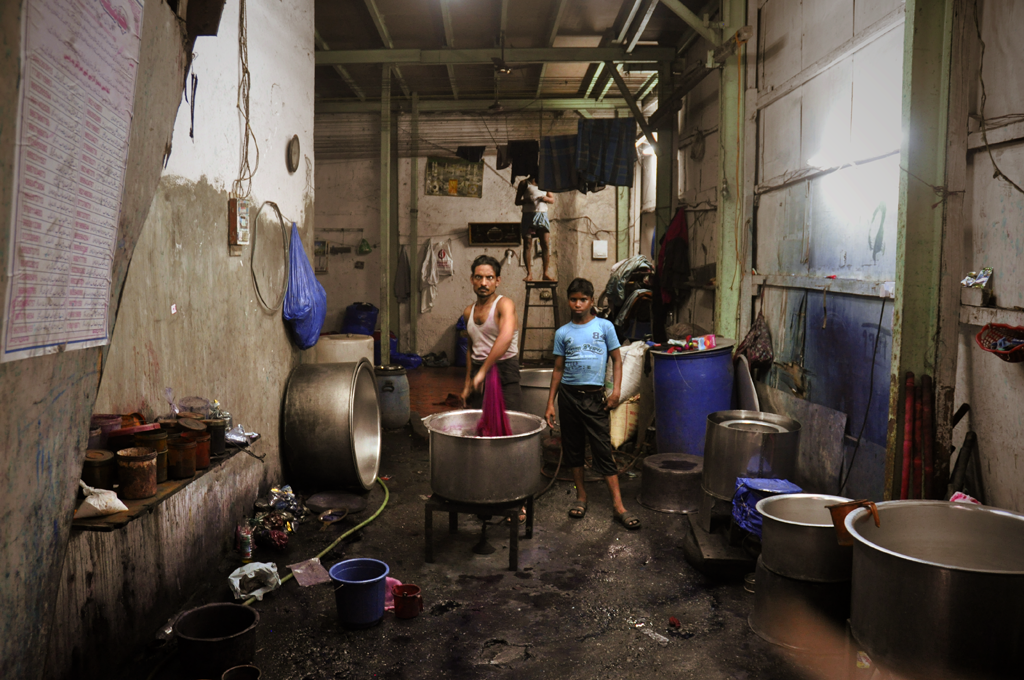 Image of men soaking and washing clothes in a factory in Dharavi.