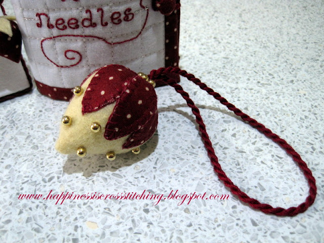 Felt strawberry finishing tutorial showing how to make this strawberry trimmed with gold beads