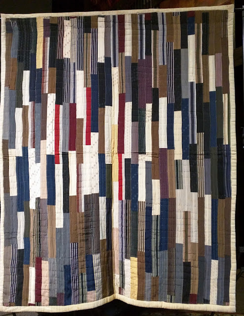 Improvisaitonal quilt from Rod Kiraofe collection. Long rectangles, possibly men's hatbands, create this white, navy, black, tan, and red quilt.