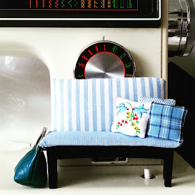 Modern miniature padded bench in blue and white, with toning cushions, displayed on a full-sized sewing machine.