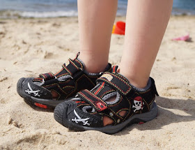 Mit tollen Kinderschuhen am Strand unterwegs (+ Verlosung)! Hier: Sandalen mit Klettverschlüssen und coolen Piraten-Motiven in schwarz-rot