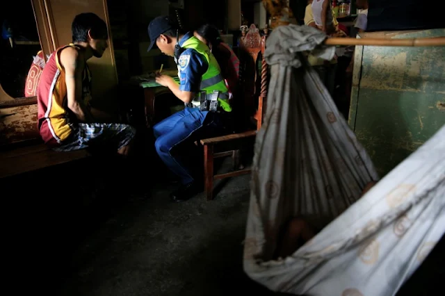 Image Attribute: A member of the Philippine National Police (PNP) documents a self-confessed drug user who voluntarily surrendered to the police on their "Operation Tokhang (approach and talk)" in Pasig city, metro Manila, Philippines  September 15, 2016. Picture taken September 15, 2016.    REUTERS/Romeo Ranoco