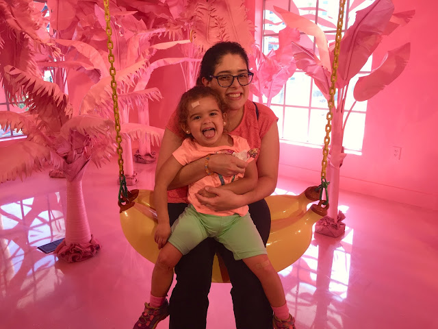 Mother and daughter seated on a swing shaped like a banana 