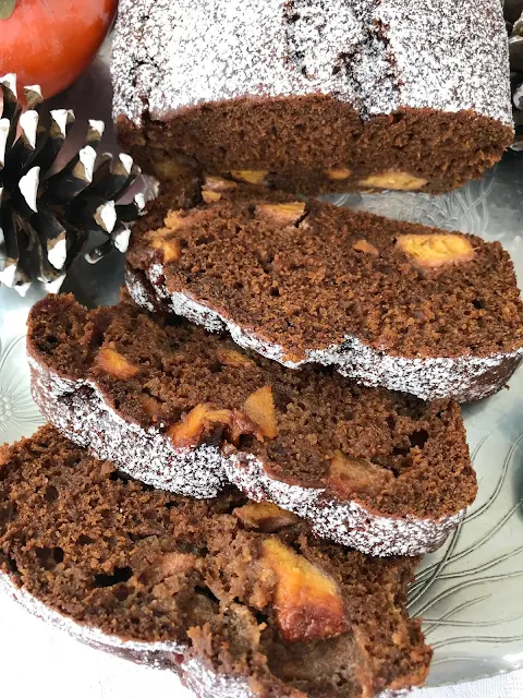 Close-up of the slices of baked persimmon gingerbread loaf cake on a platter.