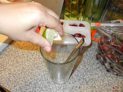 squeezing lime into a glass with a spoon 