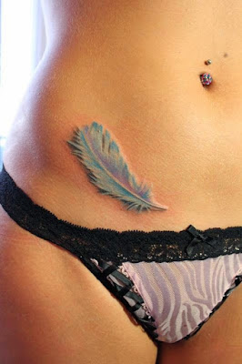 Tatuaje de pluma celeste en el abdomen