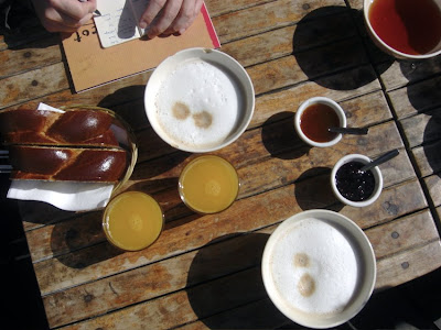 Frühstückstisch aus der Vogelperspektive: Milchkaffee, Orangensaft, Zopf und Konfitüre
