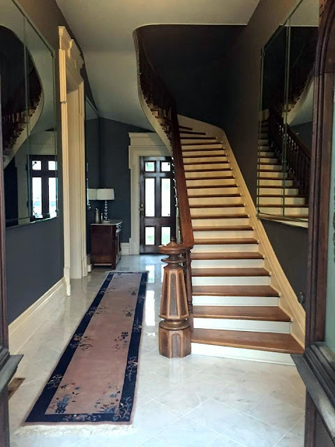 foyer with curved staircase and marble in historic home in Indiana
